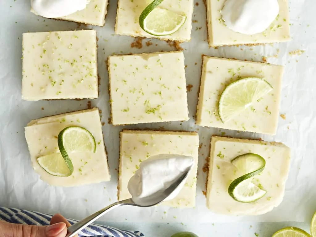 "Key Lime Pie Bars: Tangy key lime filling on a buttery graham cracker crust, cut into squares"