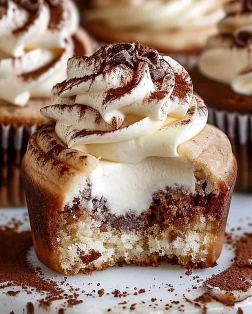 "Tiramisu Cupcake: A moist cupcake infused with coffee syrup and topped with mascarpone frosting, dusted with cocoa powder"