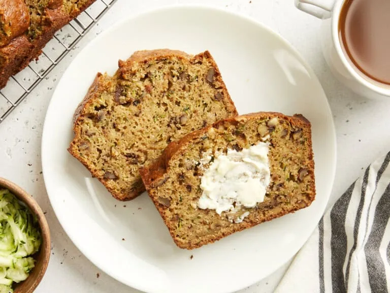 "Zucchini Bread: A moist and flavorful loaf of bread made with grated zucchini, served in slices"